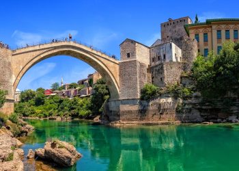 Dolje južno, nastao iz krša, sija suncem obasjan grad: Ko bi mog'o opjevati redom sve ljepote divnoga Mostara?